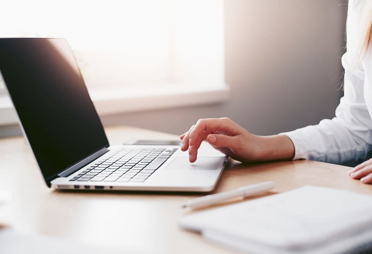 smiling person laptop outdoor stock market investing